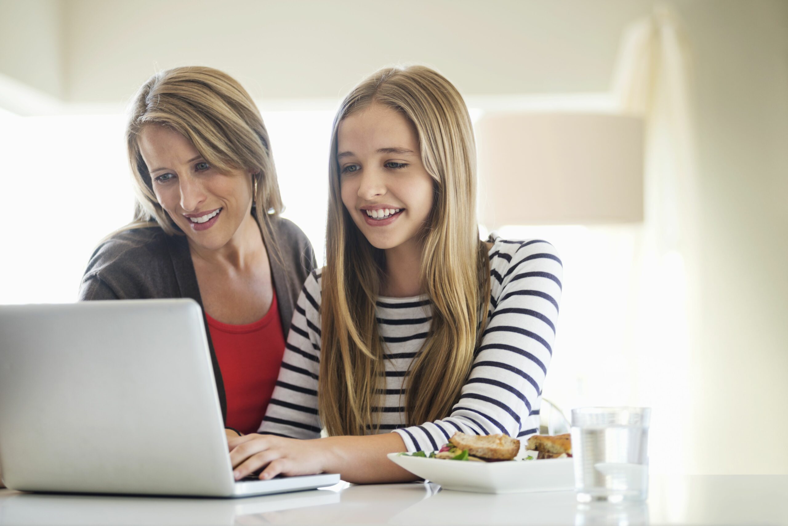 mother and daughter using laptop together at home 179414579 4381f0ceb52048e3950b7de45011902e scaled