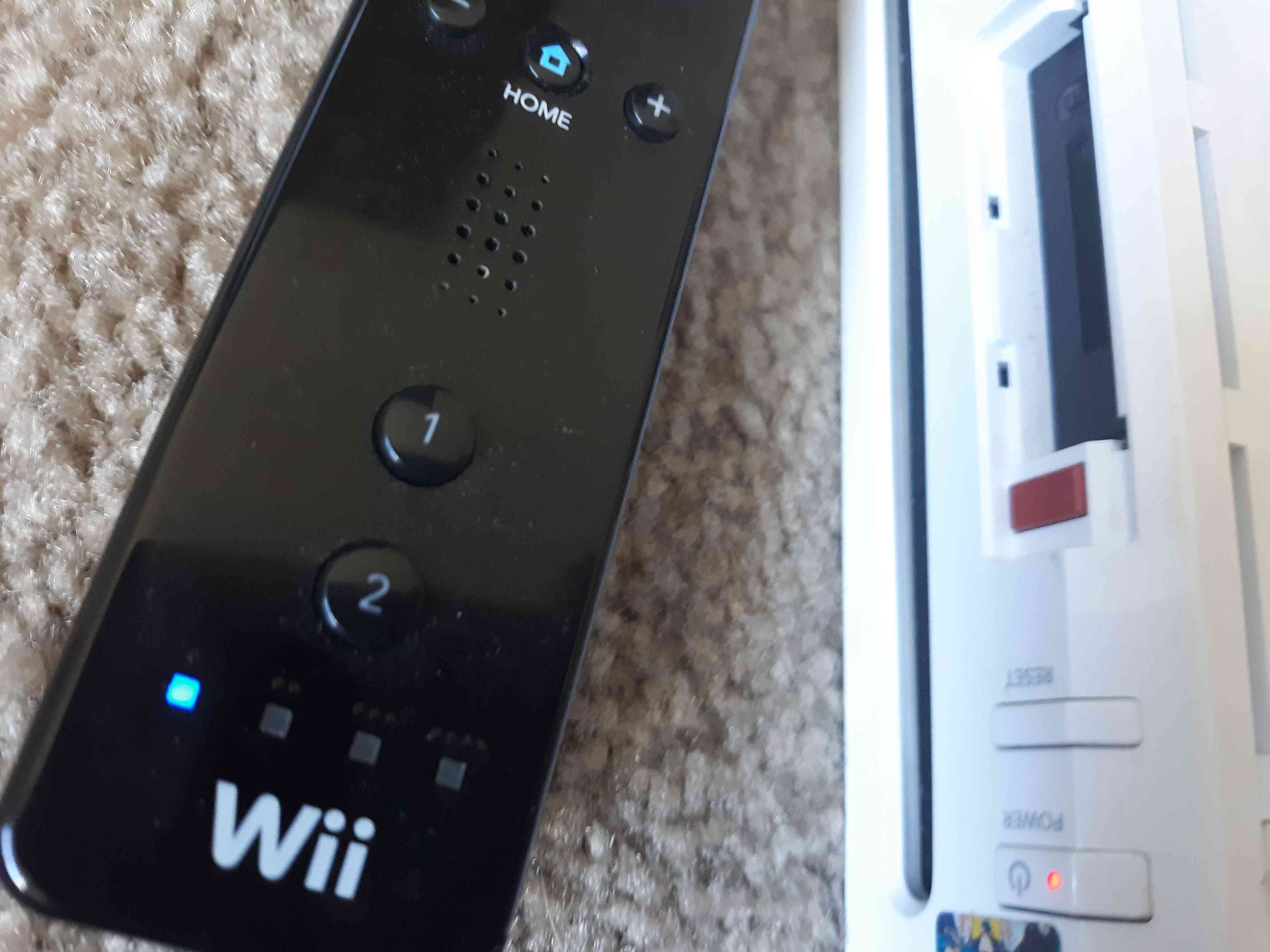 Wii Remote -kaukosäätimen LED-valo vilkkuu Wiin punaisen synkronointipainikkeen vieressä.