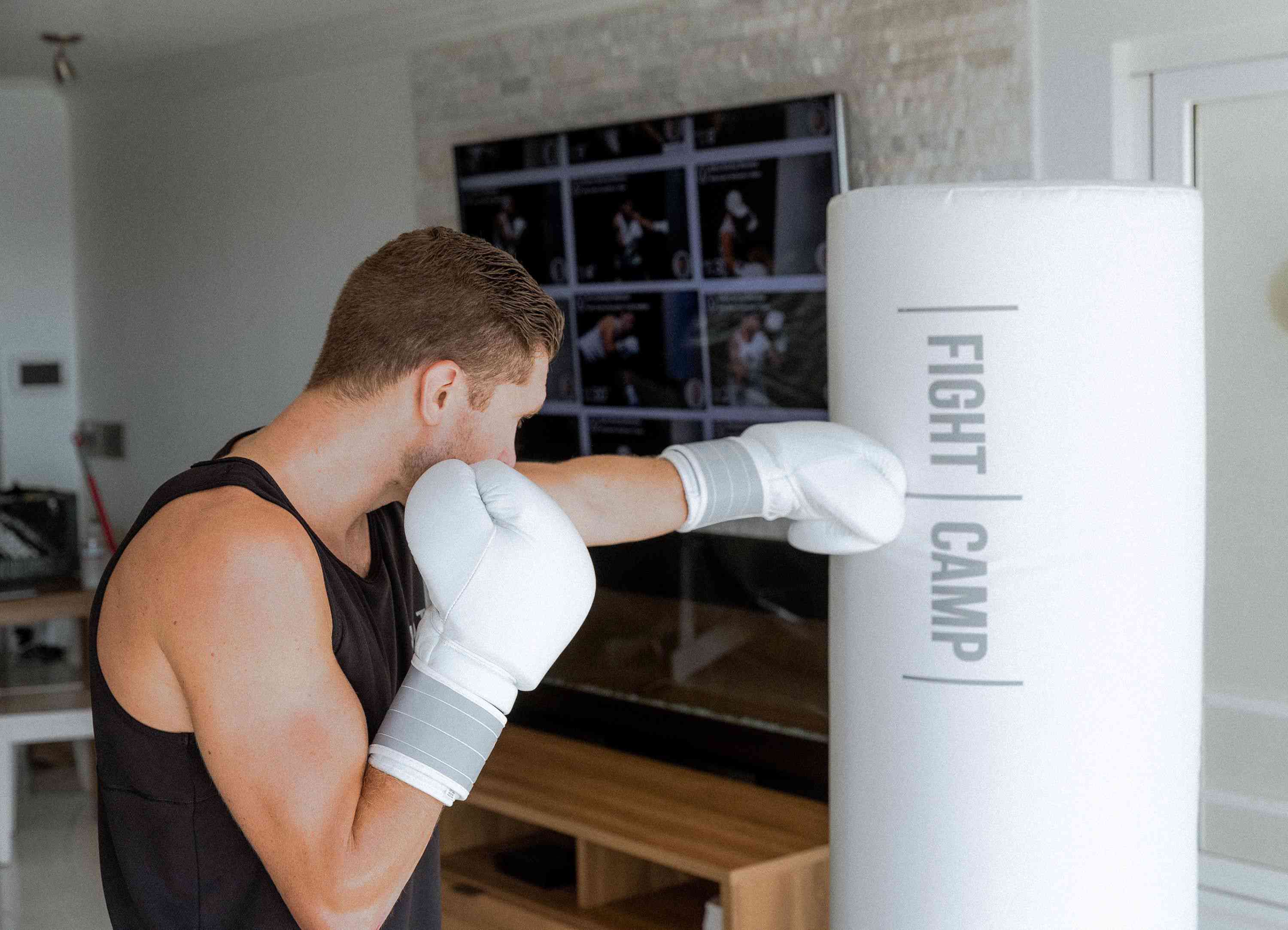 Joku, joka käyttää FightCamp Boxing Traineria kotonaan. 