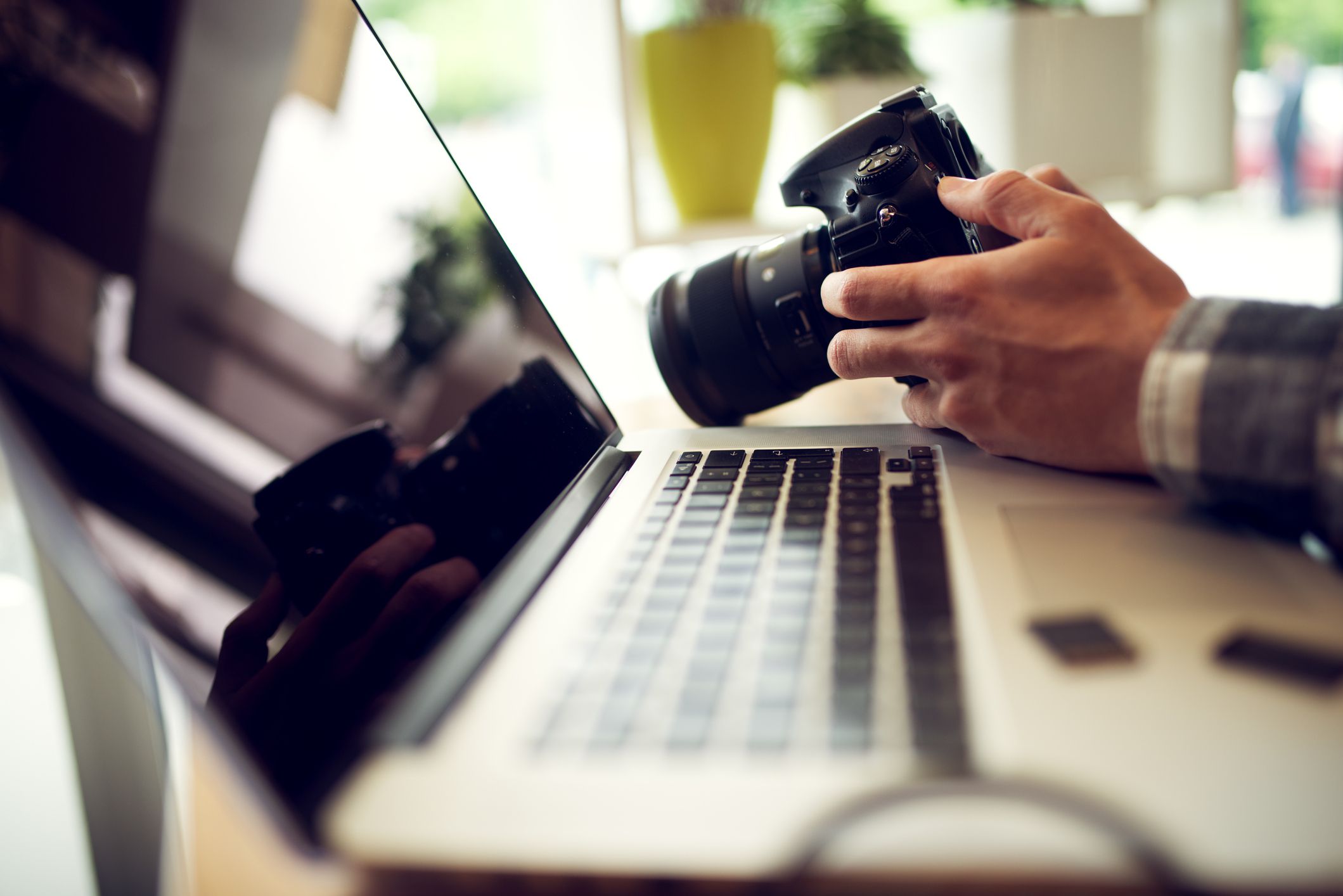 close up photographer hands adjusting settings on his camera in office 918318318 007af521082743cb8abacbf2c7ebb29a