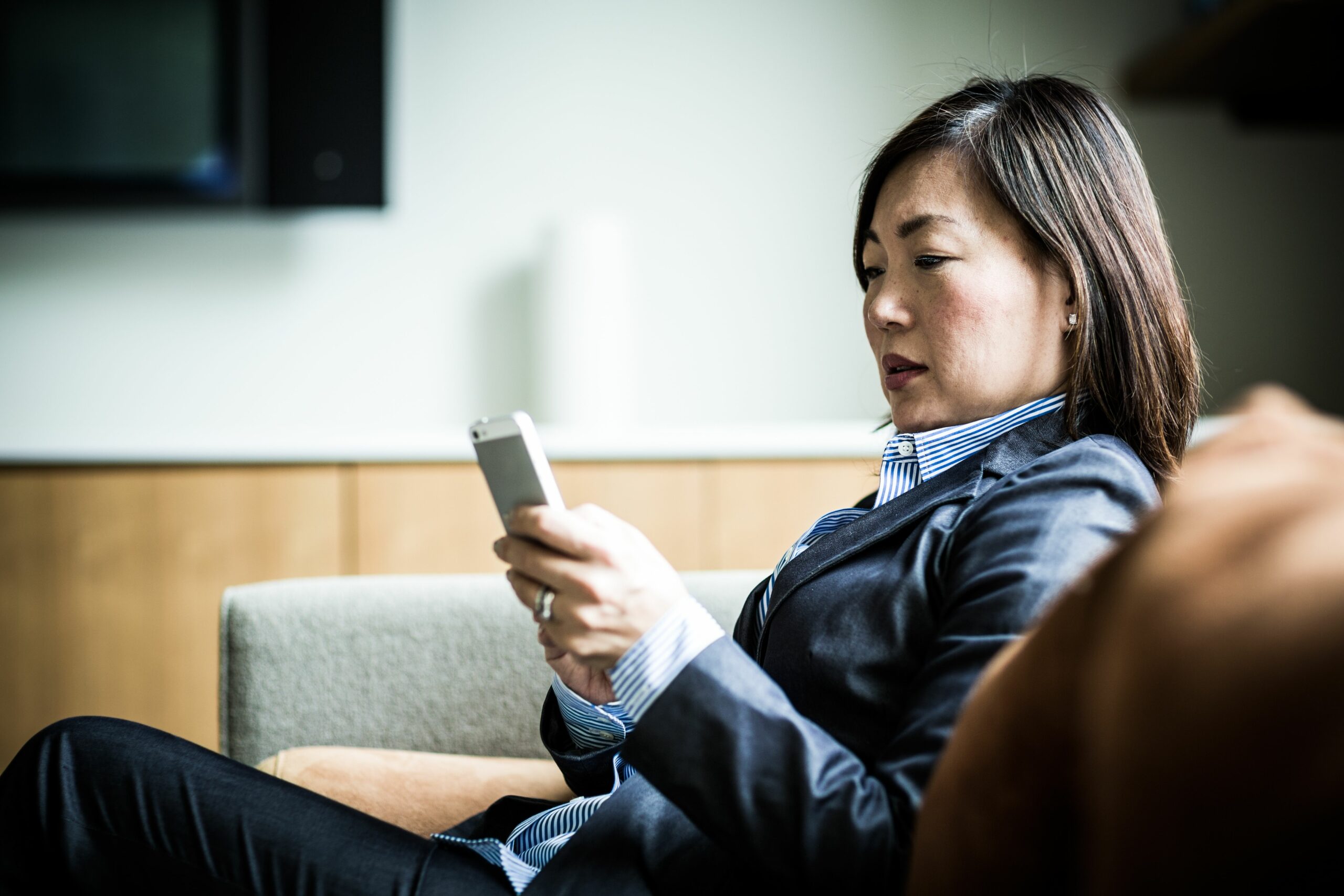 woman using smartphone on couch 485987951 57a22b015f9b589aa9079532 scaled