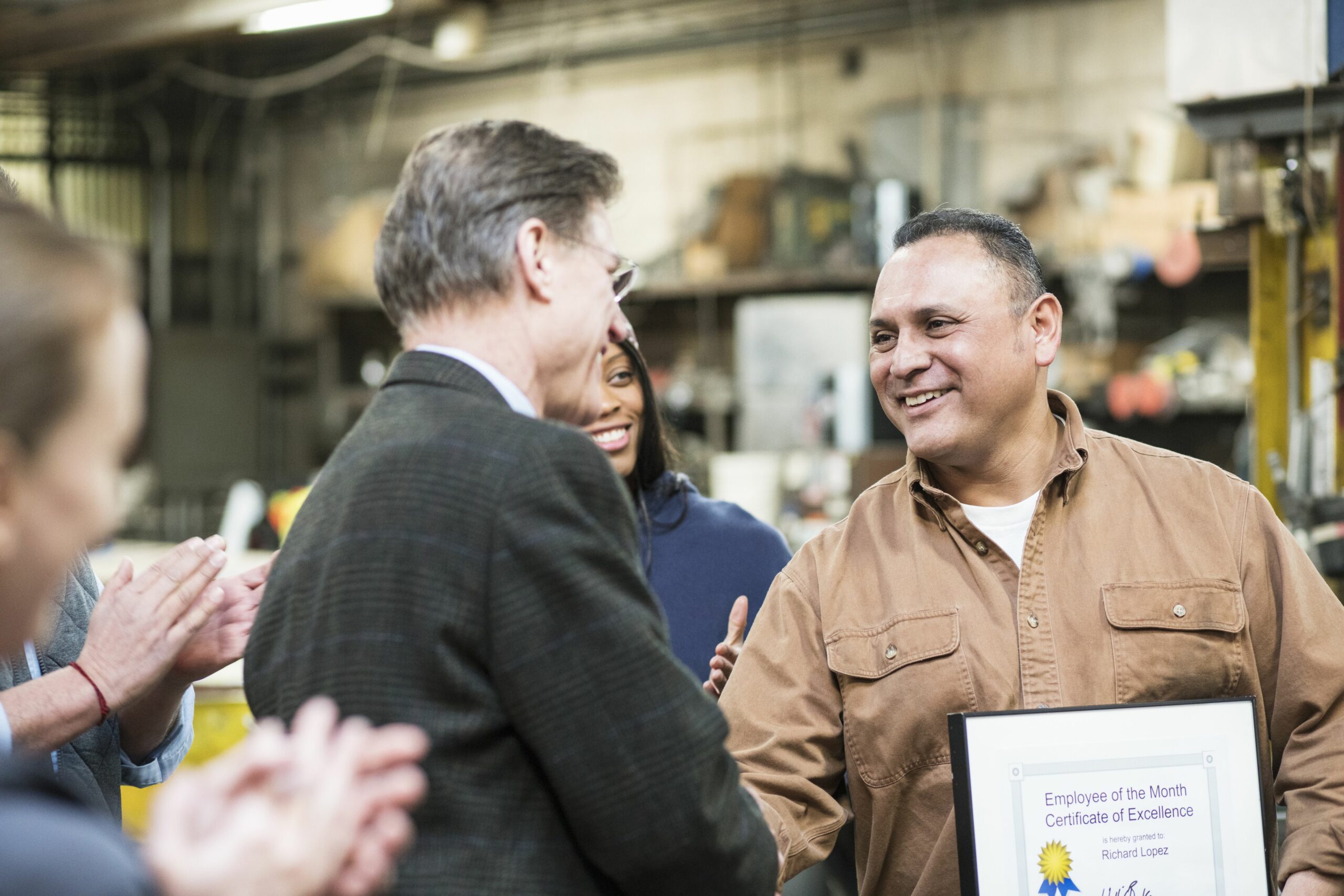 worker receiving award in workshop 649662449 5b9d4154c9e77c0050d1885a scaled