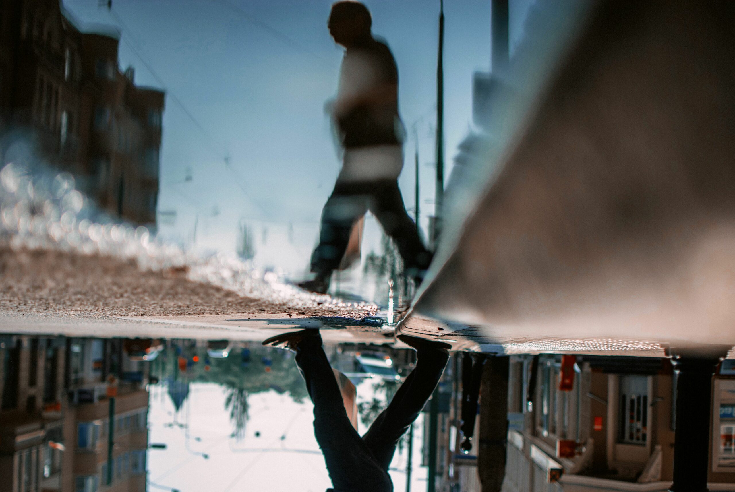 low section of man walking on road with reflection in puddle 758488257 5c2015b846e0fb0001c48d87 scaled