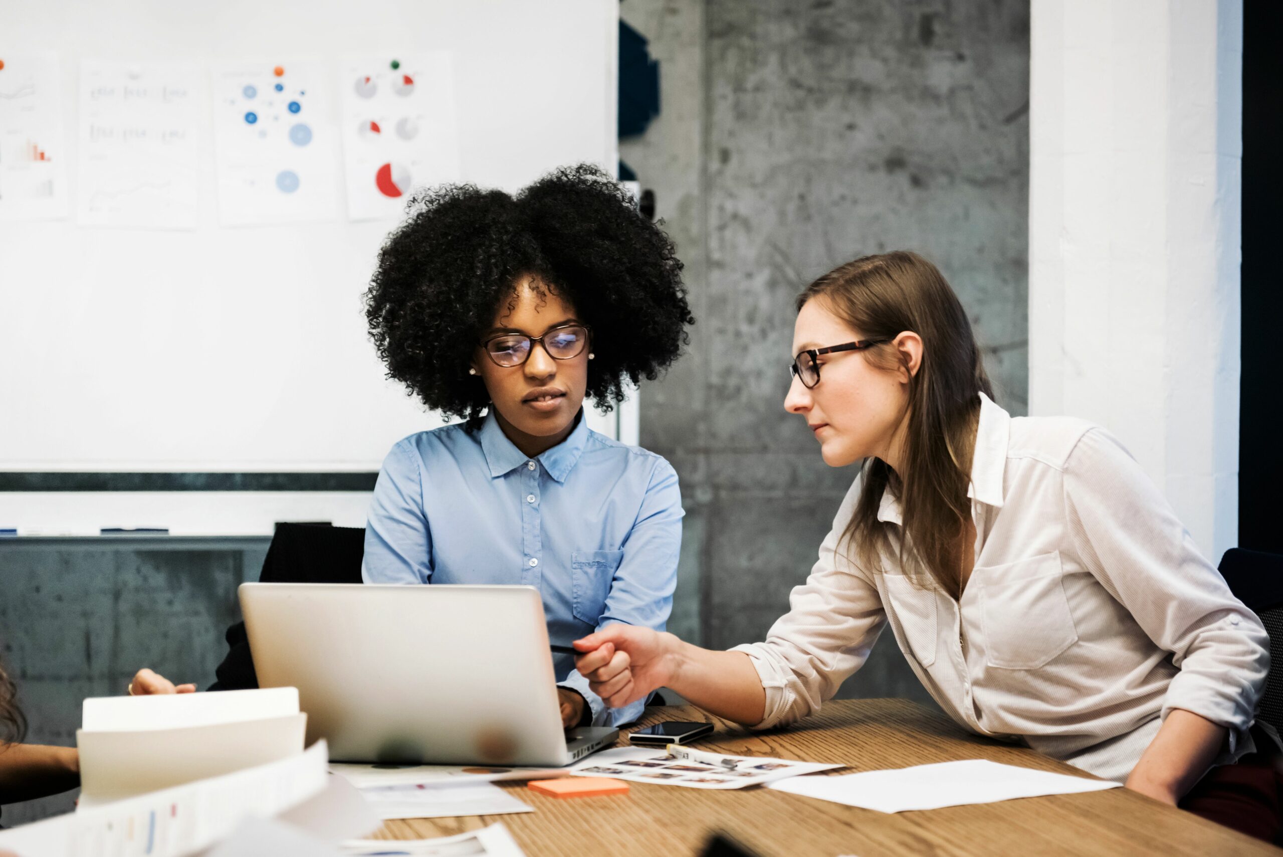 two young women having a discussion in a business 607477463 5a32f91aec2f640037522ed6 scaled