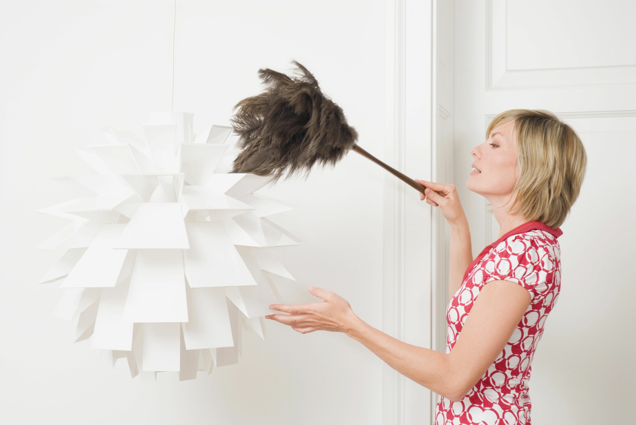 woman dusting a lamp with a feather duster 535256610 5b377454c9e77c001ae7dfcb scaled