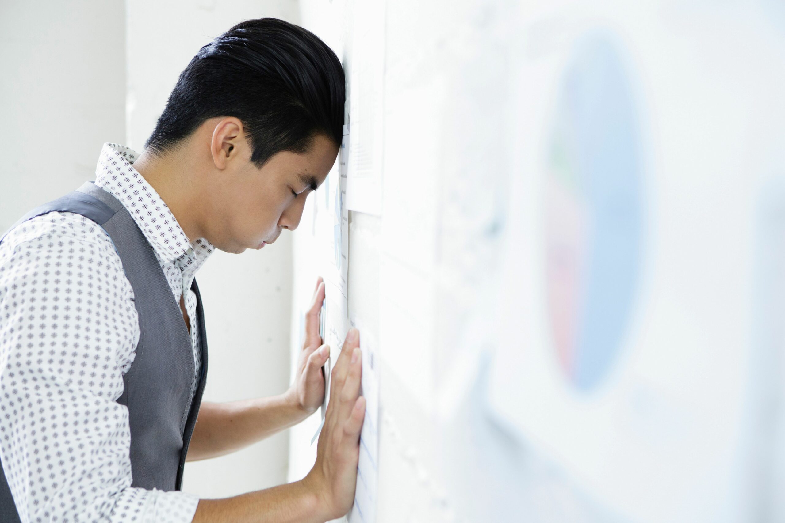 young man in office with head and hands against wall 176640285 5961b0d55f9b583f180cd3ac scaled