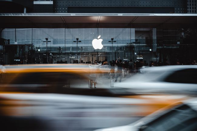 Apple-myymälän etuosa vilkkaan kadun toisella puolella, jossa on ohikulkuliikennettä. 