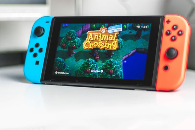 Nintendo Switch seisoo telineellä ja pyörittää Animal Crossing: New Horizons -peliä