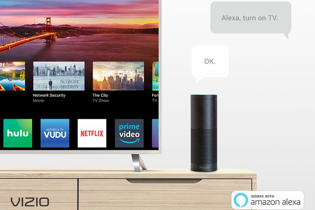 Amazon Echo lähellä Vizio-älytelevisiota.  "Alexa, laita televisio päälle."  "OKEI."