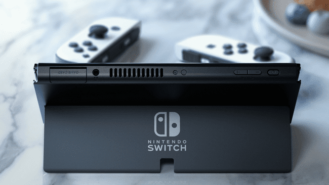 Nintendo Switch OLED uudella jalustalla ja valkoisilla ohjaimilla marmoripöydällä