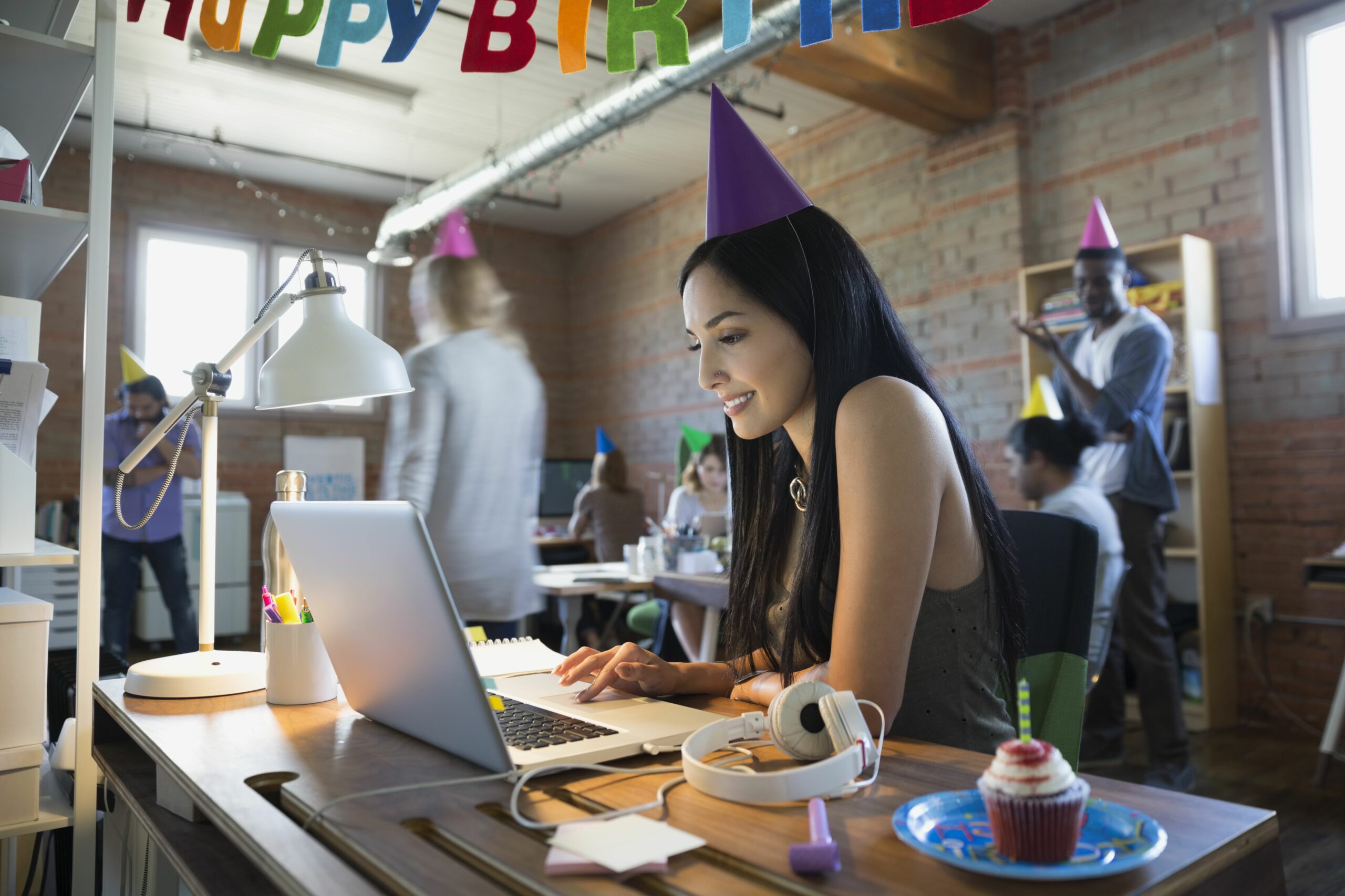 businesswoman wearing birthday party hat at laptop 645426519 5a09fa4c22fa3a003677819c scaled