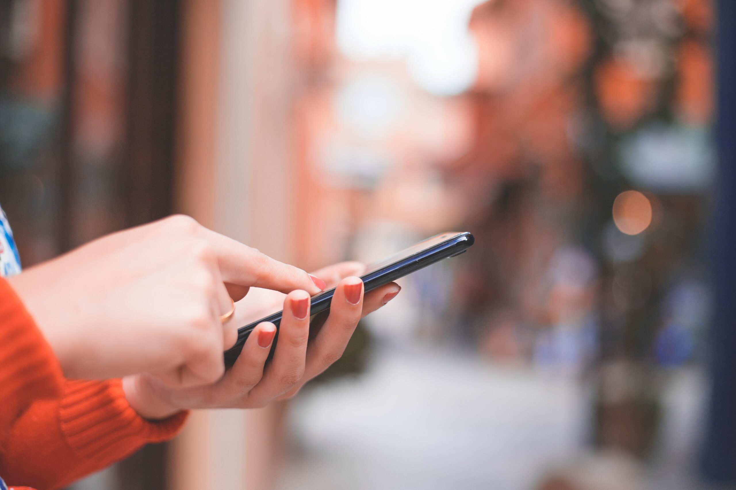 cropped hands of woman using phone on footpath 1144099154 d8eb34d9a2034485a20f49a79936d009 scaled