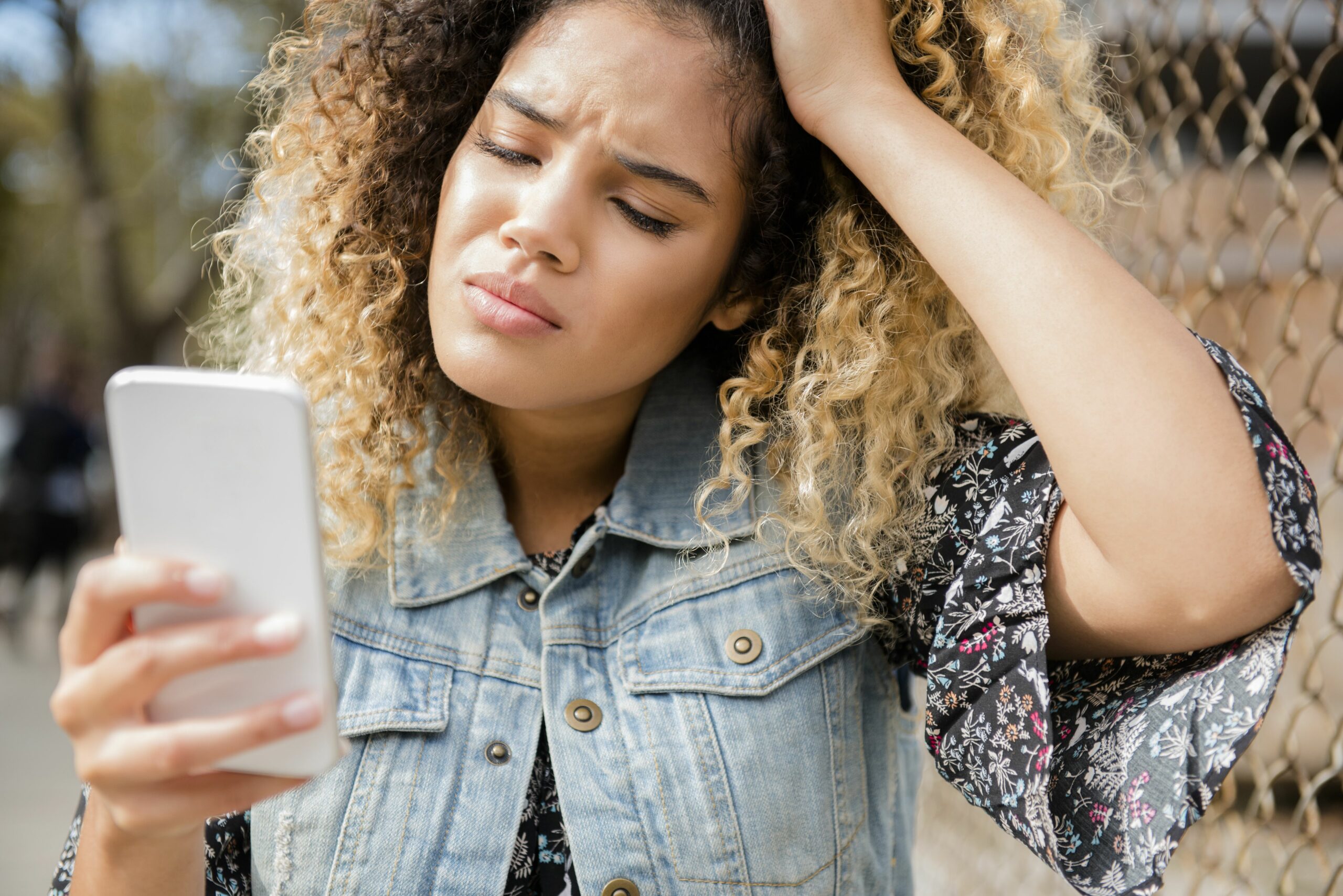 unhappy mixed race woman texting on cell phone 700712379 5c1c118546e0fb000150bdb9 scaled