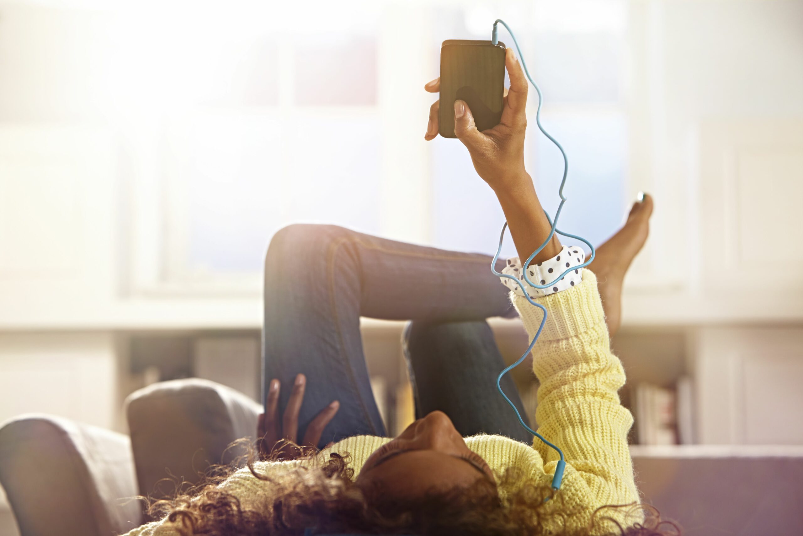 woman relaxing at home listening to her phone 479977911 5b3e3217c9e77c003701b598 scaled