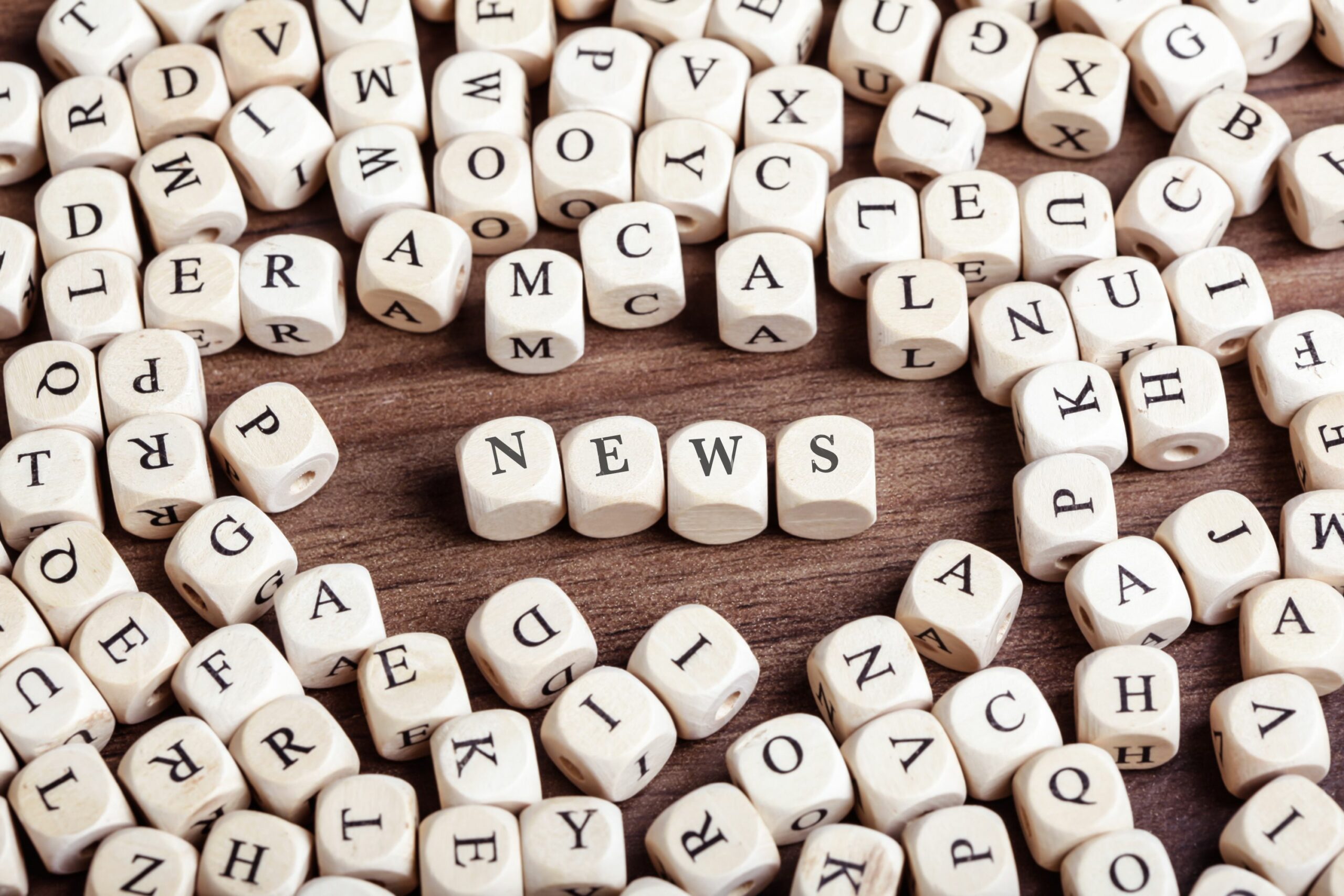 high angle view of news text arranged with alphabet blocks on wooden table 746119745 5bdf213bc9e77c0051ac3ce2 scaled