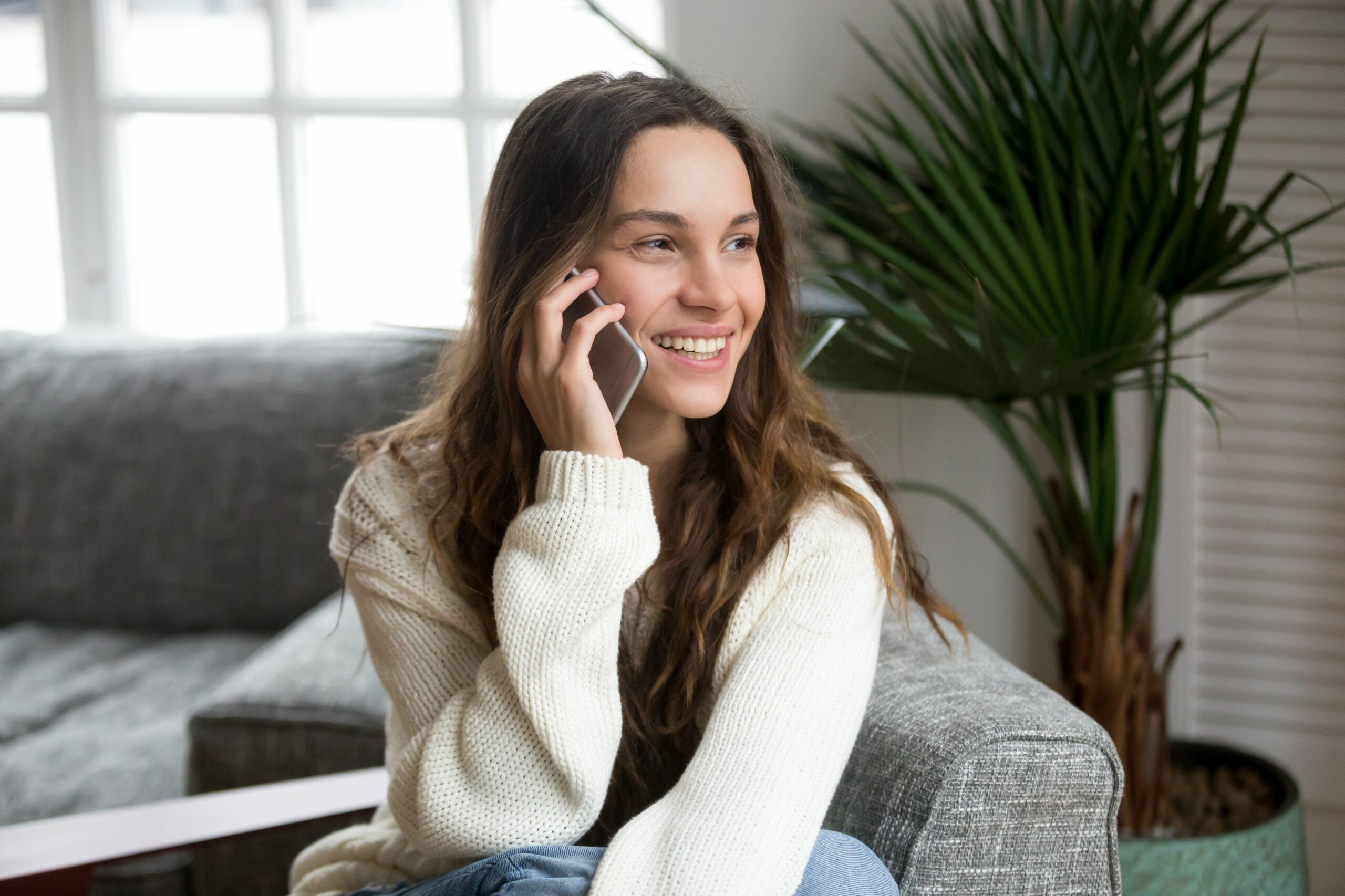 smiling millennial mestizo woman talking on the phone at home 934913078 5afd8c038023b9003692d3c1 scaled