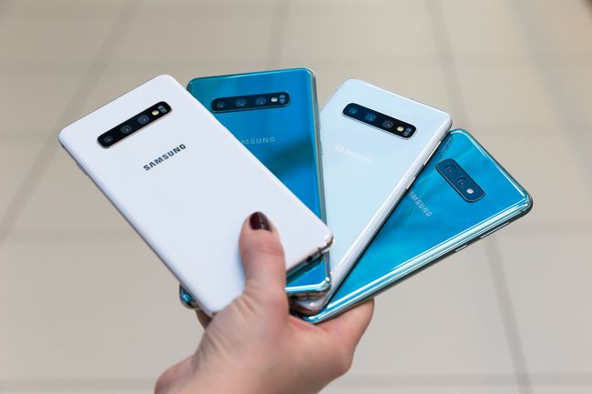 Joku pitää kädessään 4 Samsung Galaxy S10 -puhelinta