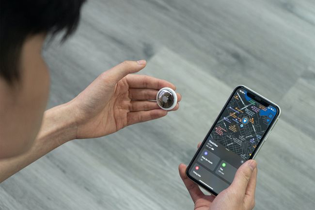 Joku pitelee AirTagia ja katsoo sijaintia Applen Find My -verkon avulla.