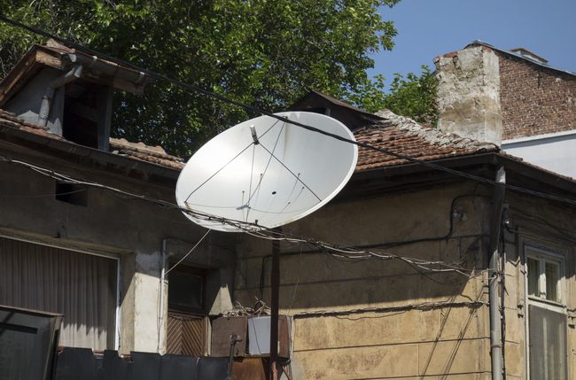 Satelliitti-tv-antenni talon ulkopuolella.