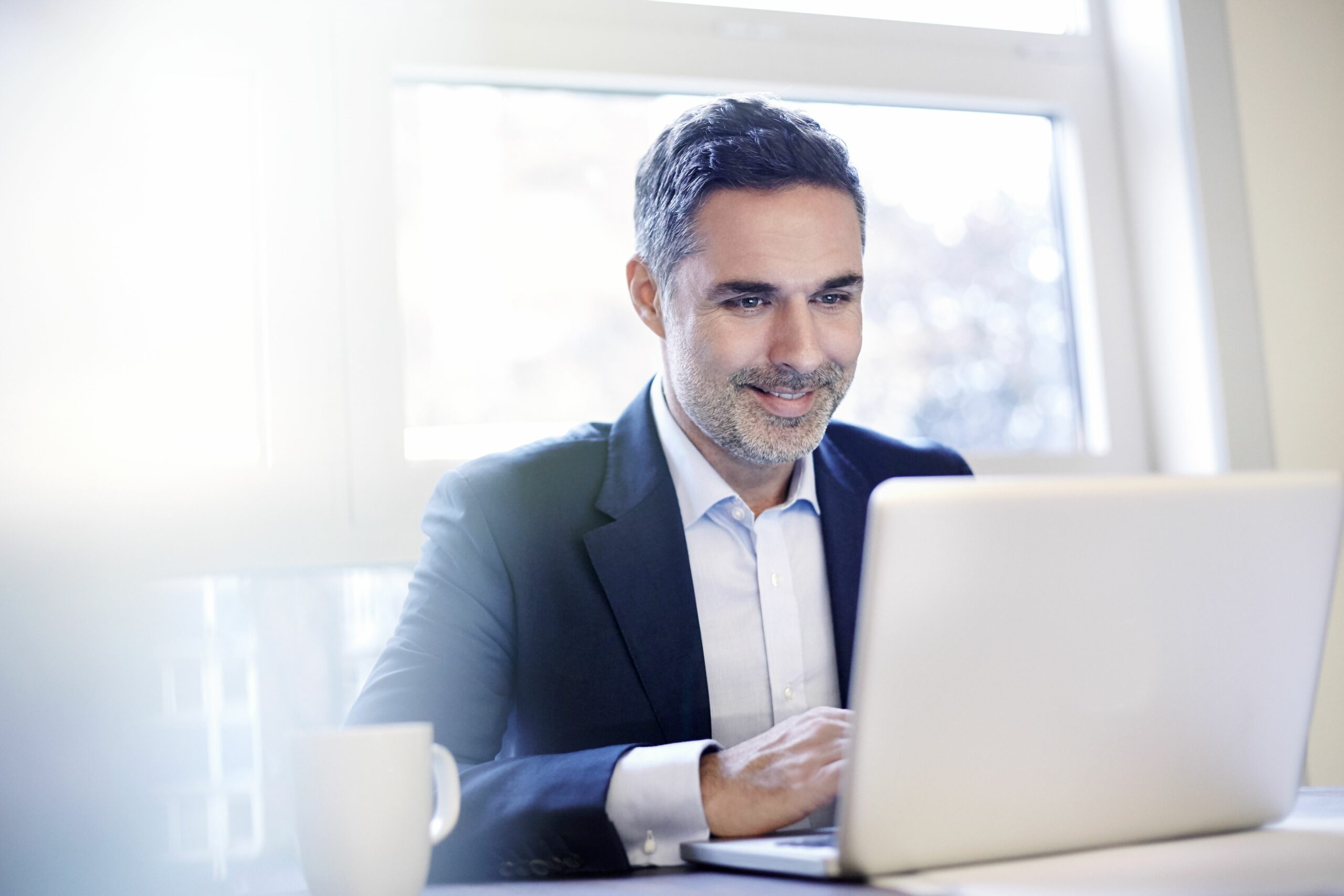 businessman working on a laptop smiling 528913599 59e9143faad52b00115fefaf scaled