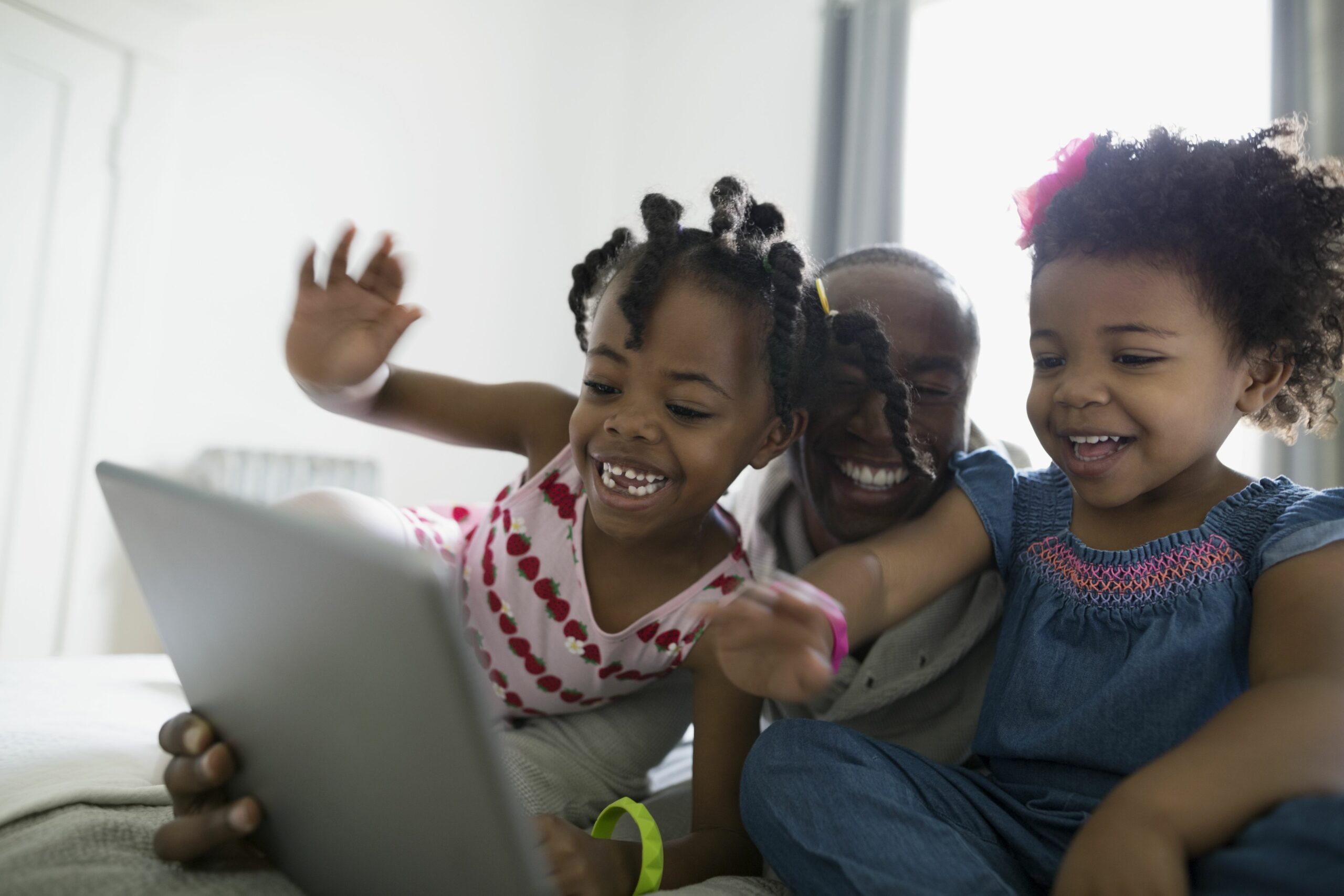 father and daughters waving video chatting using digital tablet 664657787 5b896d0fc9e77c002588cc13 scaled