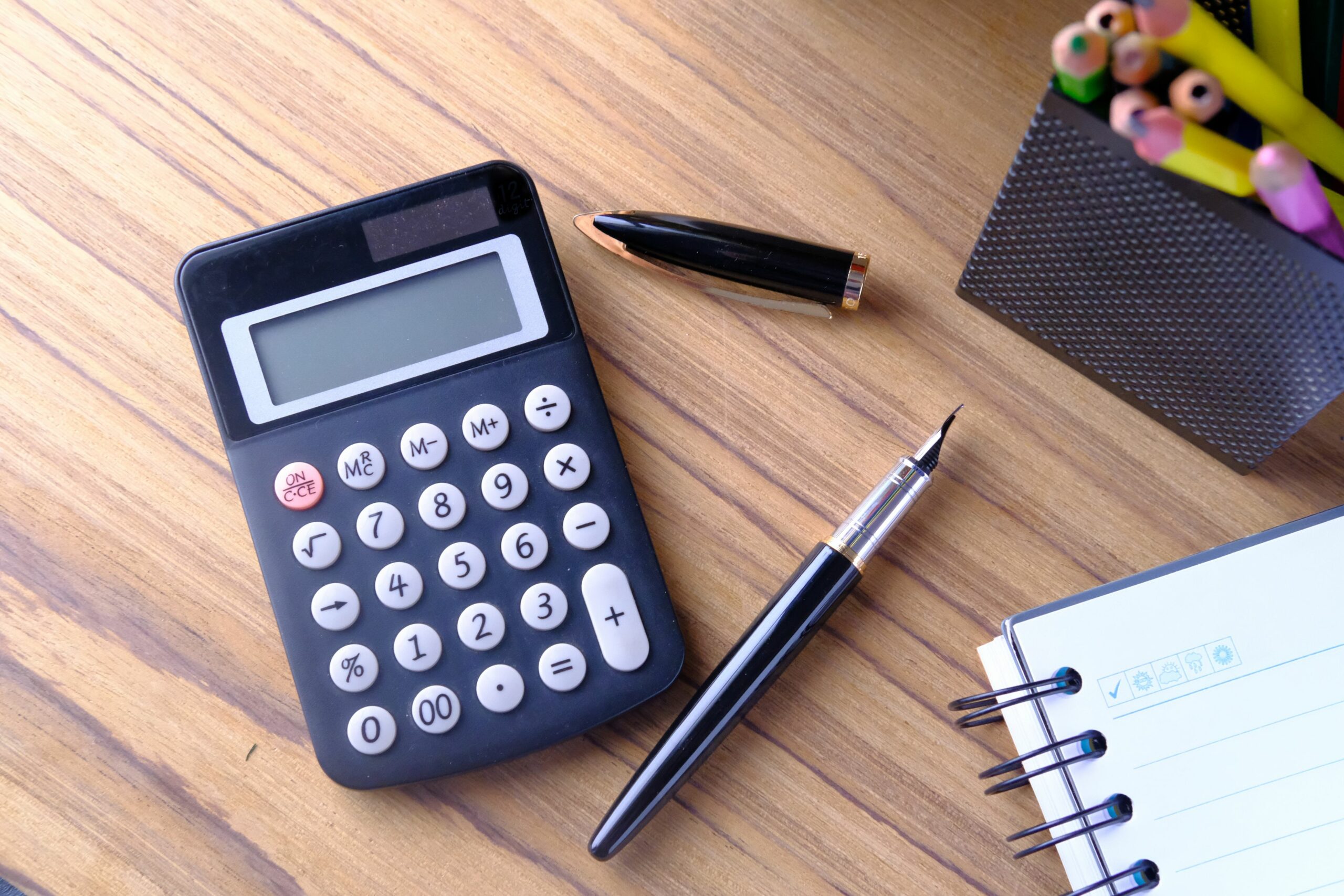 financial notebook and pen on wooden table 898648150 5be08ebfc9e77c0051722644 scaled