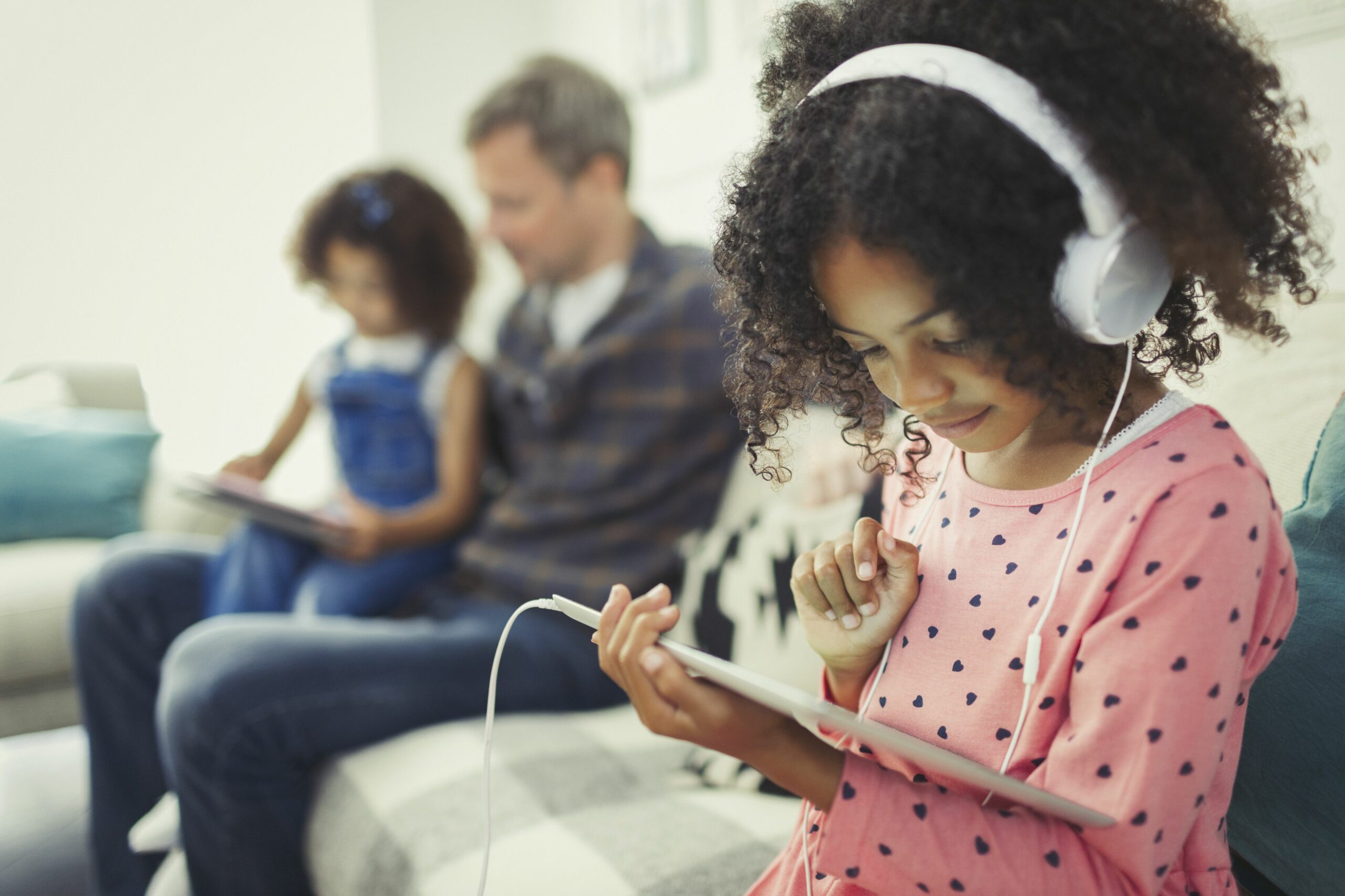 girl with headphones using digital tablet on sofa 726783271 5b3ce2a346e0fb00372de2ba scaled