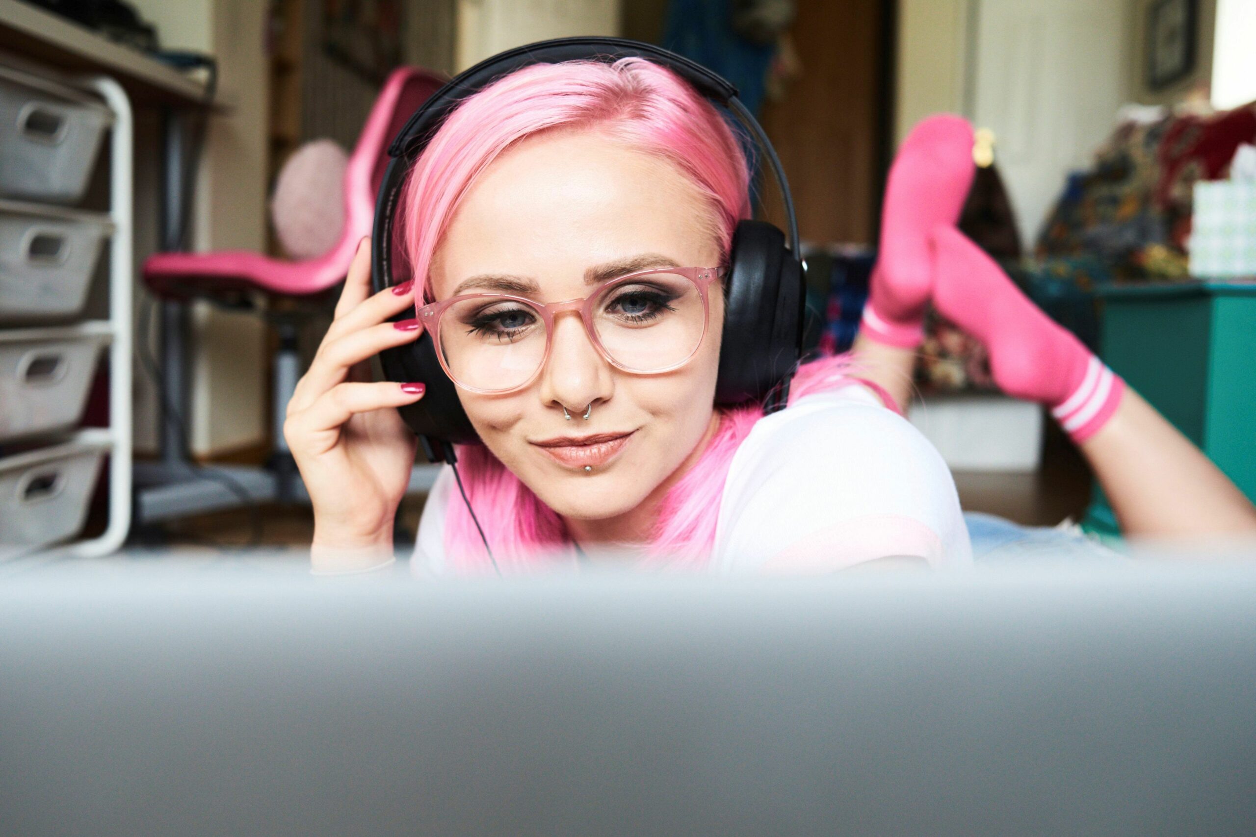 young woman with pink hair listening to music via laptop at home 769729445 5a36dfedaad52b0036c213f3 5c057421c9e77c0001694fb9 scaled