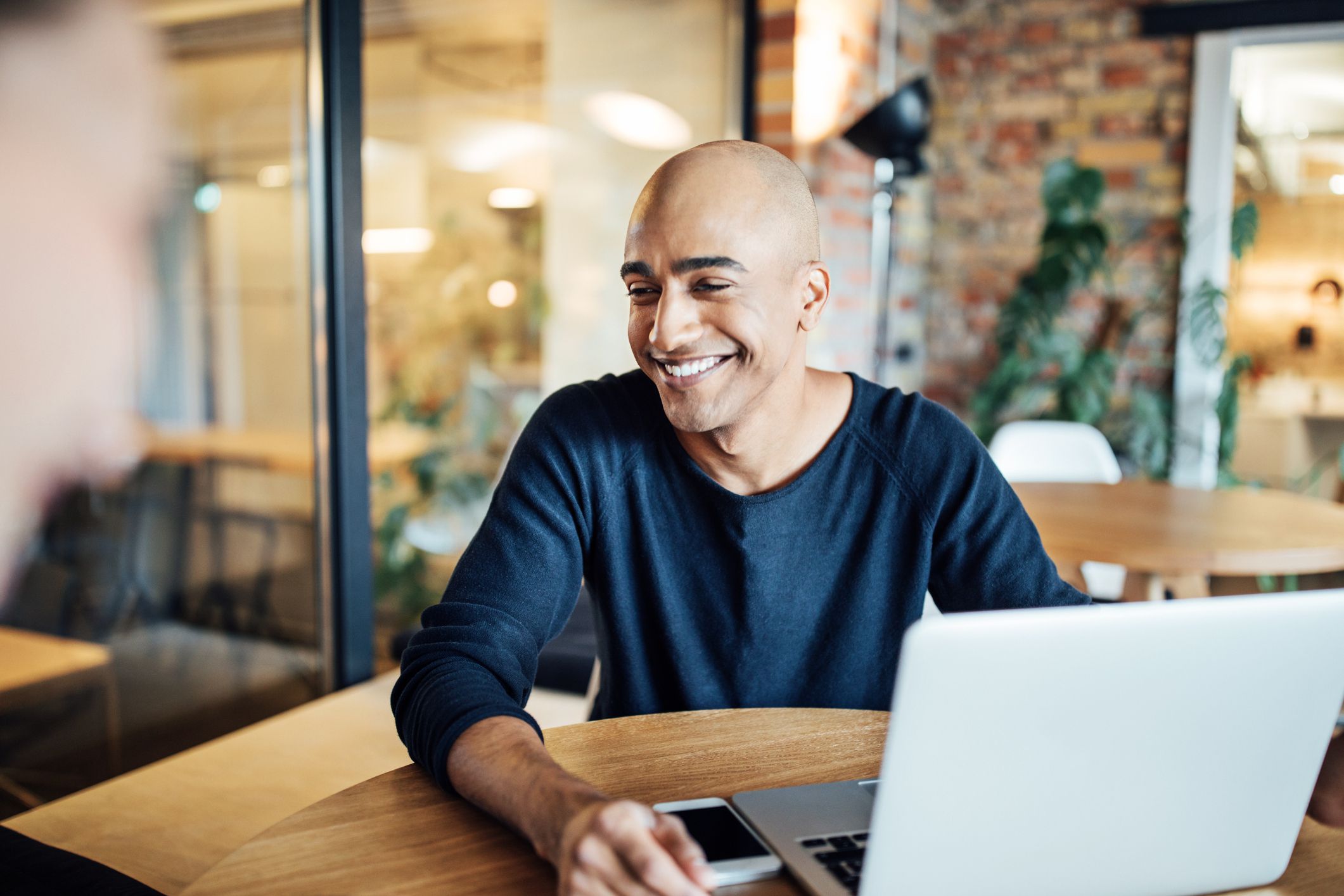 smiling businessman with laptop at office cafeteria 875593414 5c476f5cc9e77c0001ce026c