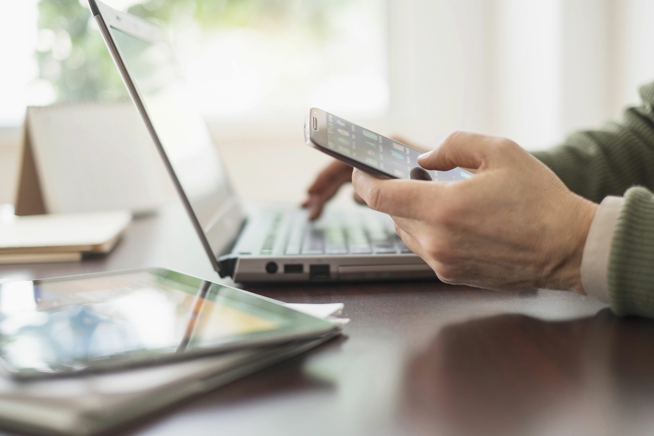 close up of mans hands working at desk with electronic devices 555173169 573f138a5f9b58723de8bfe1 scaled