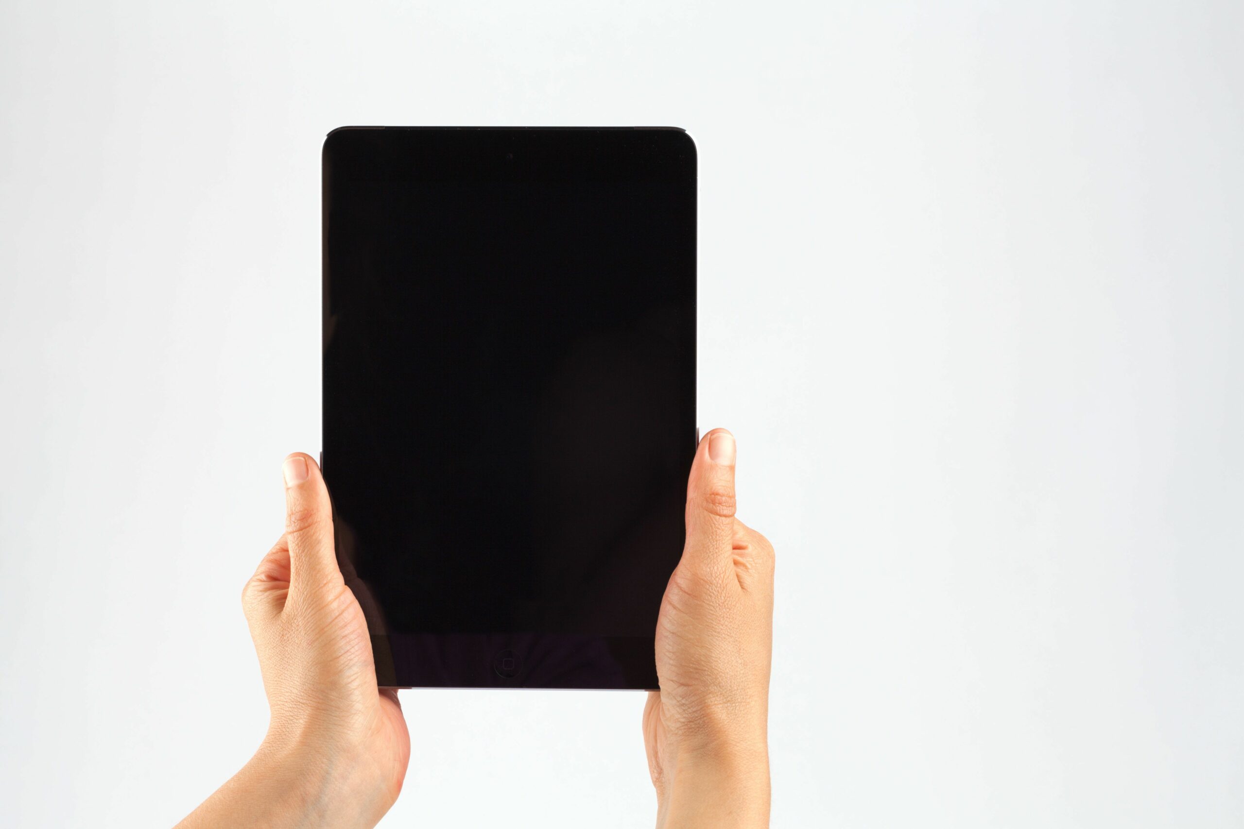 cropped hands of person holding digital tablet against white background 903957418 5b898708c9e77c007b5ecdce scaled