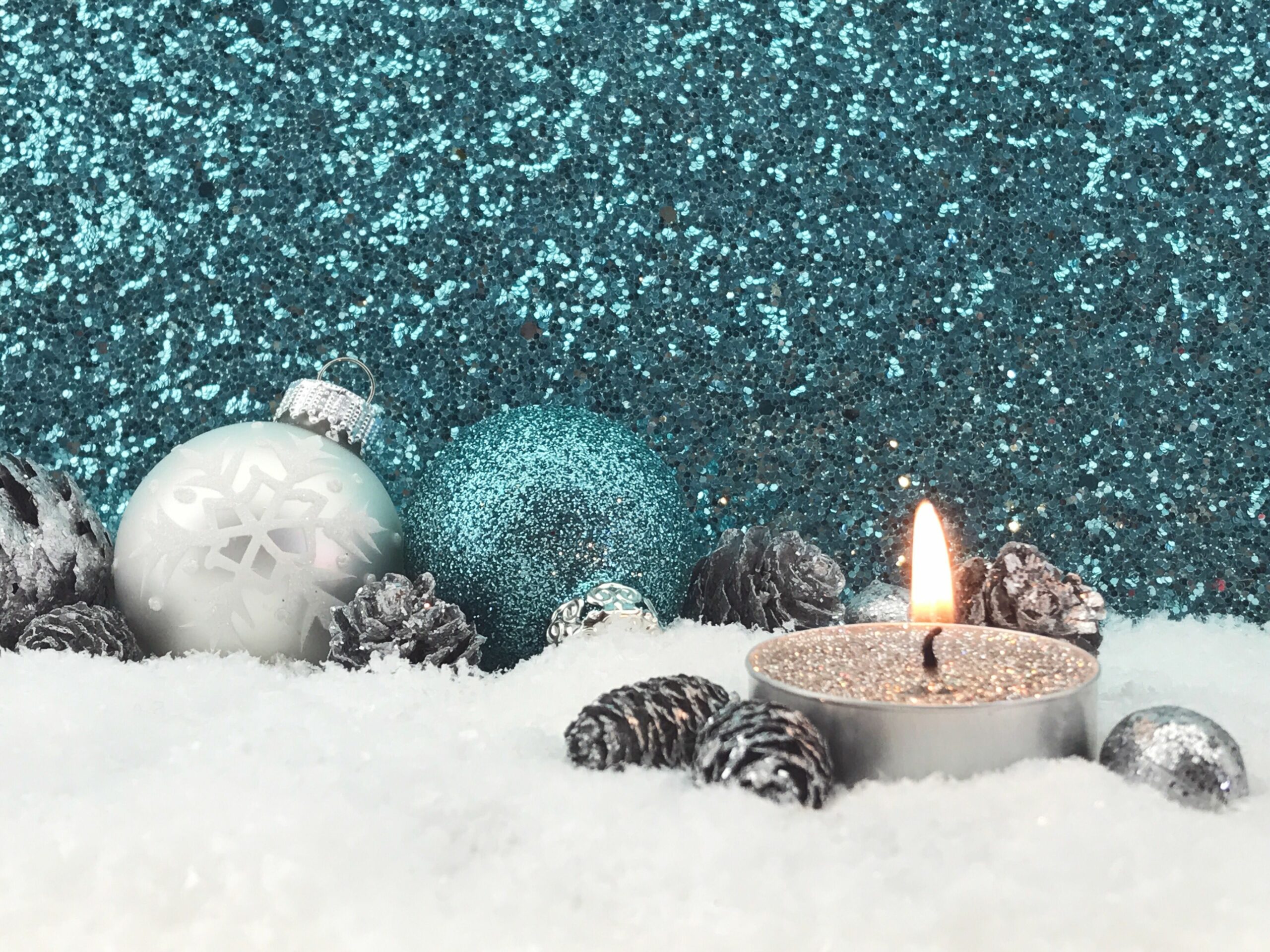 lit candle with christmas decoration on fake snow against glittering wall 758535587 5b480cf346e0fb0037182125 scaled