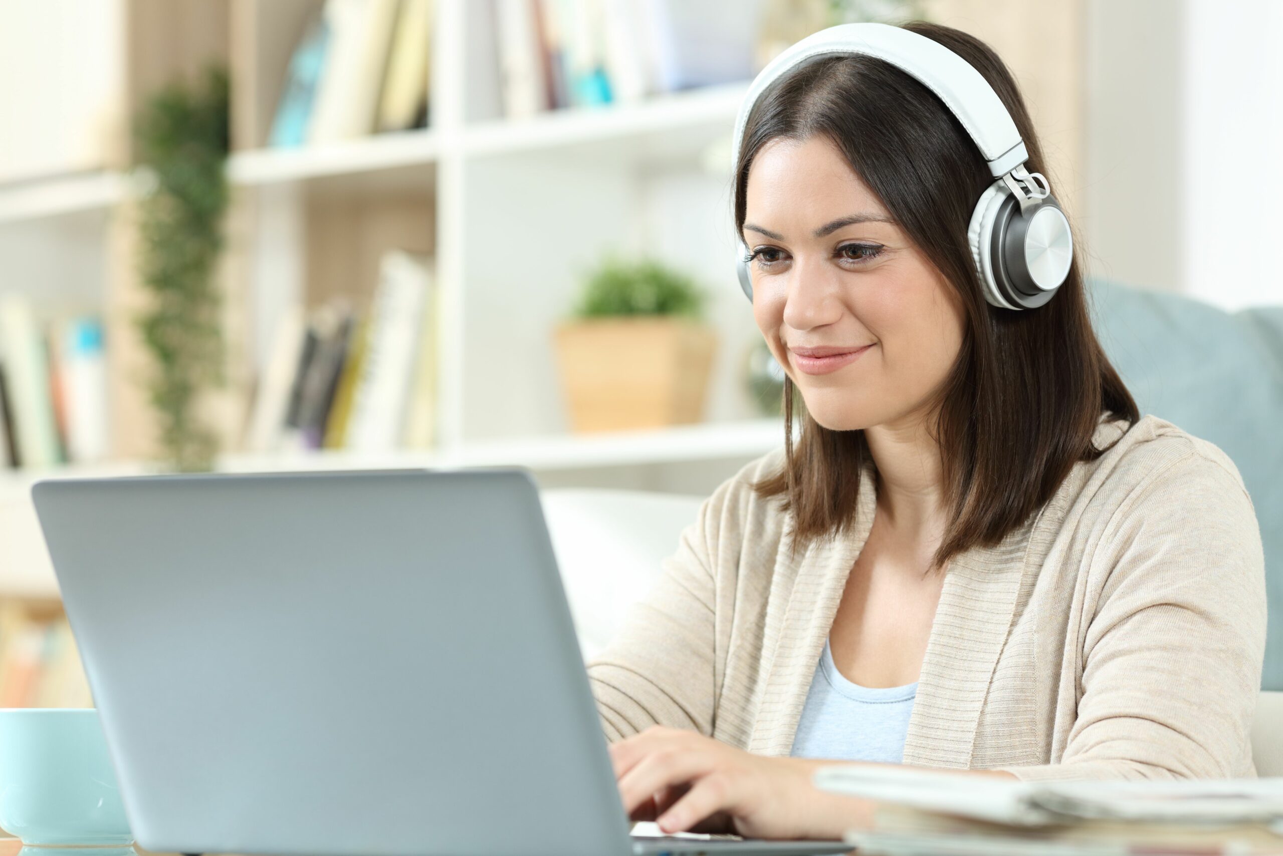 woman with headphones and laptop at home 1280611332 e84e8ba7fbea449b82ced11c31cf7160 scaled