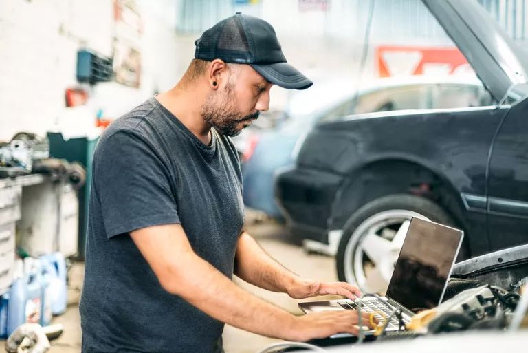 Automekaanikko ja tietokone kytkettynä autoon