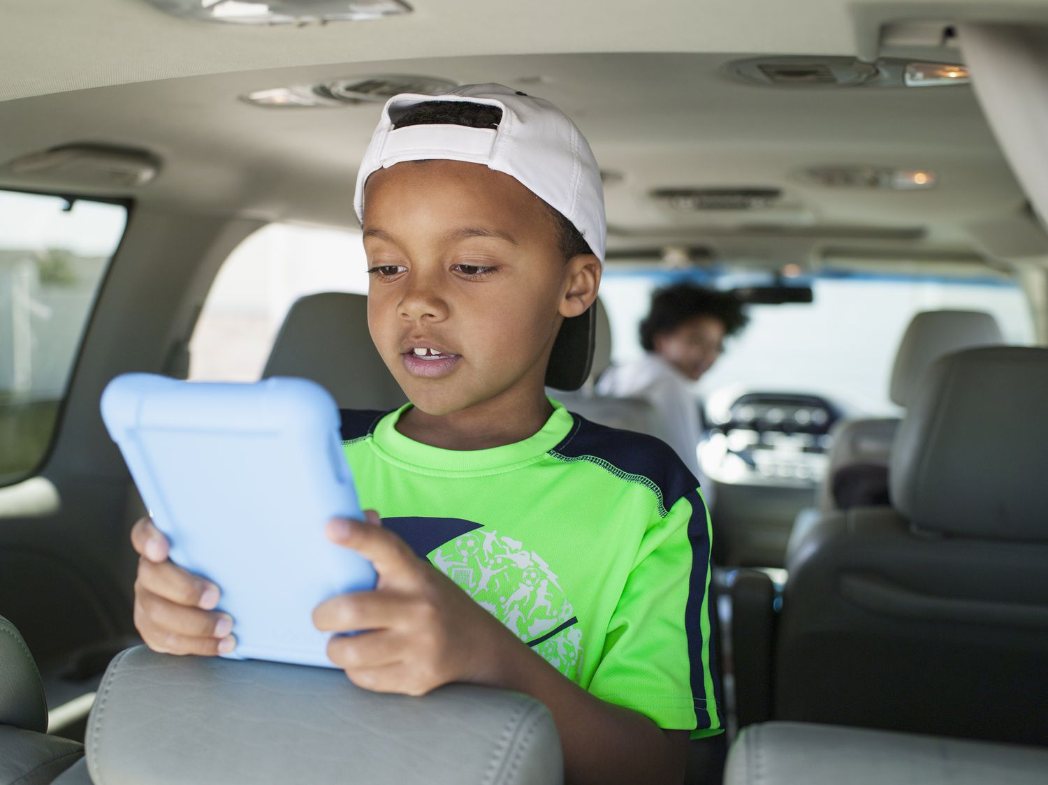 boy with tablet in minivan teenaged sister driving 580521807 5b9d510b46e0fb0024515512