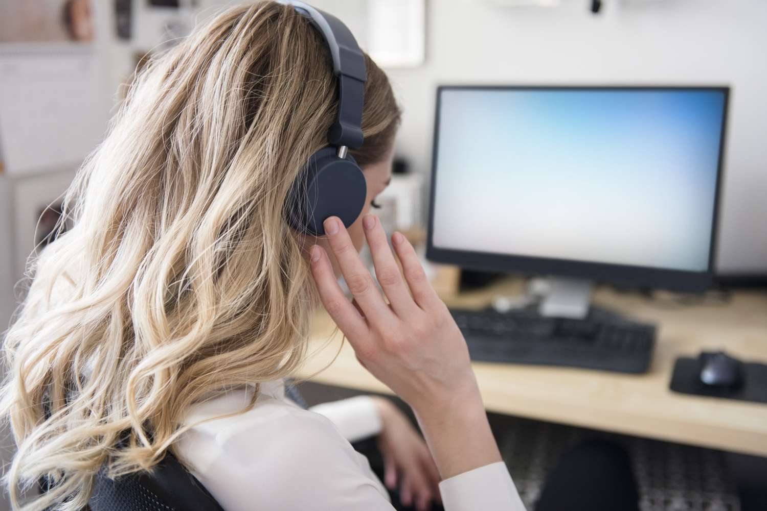 caucasian woman listening to headphones at computer desk 758282915 5c9019ee46e0fb00015558f5